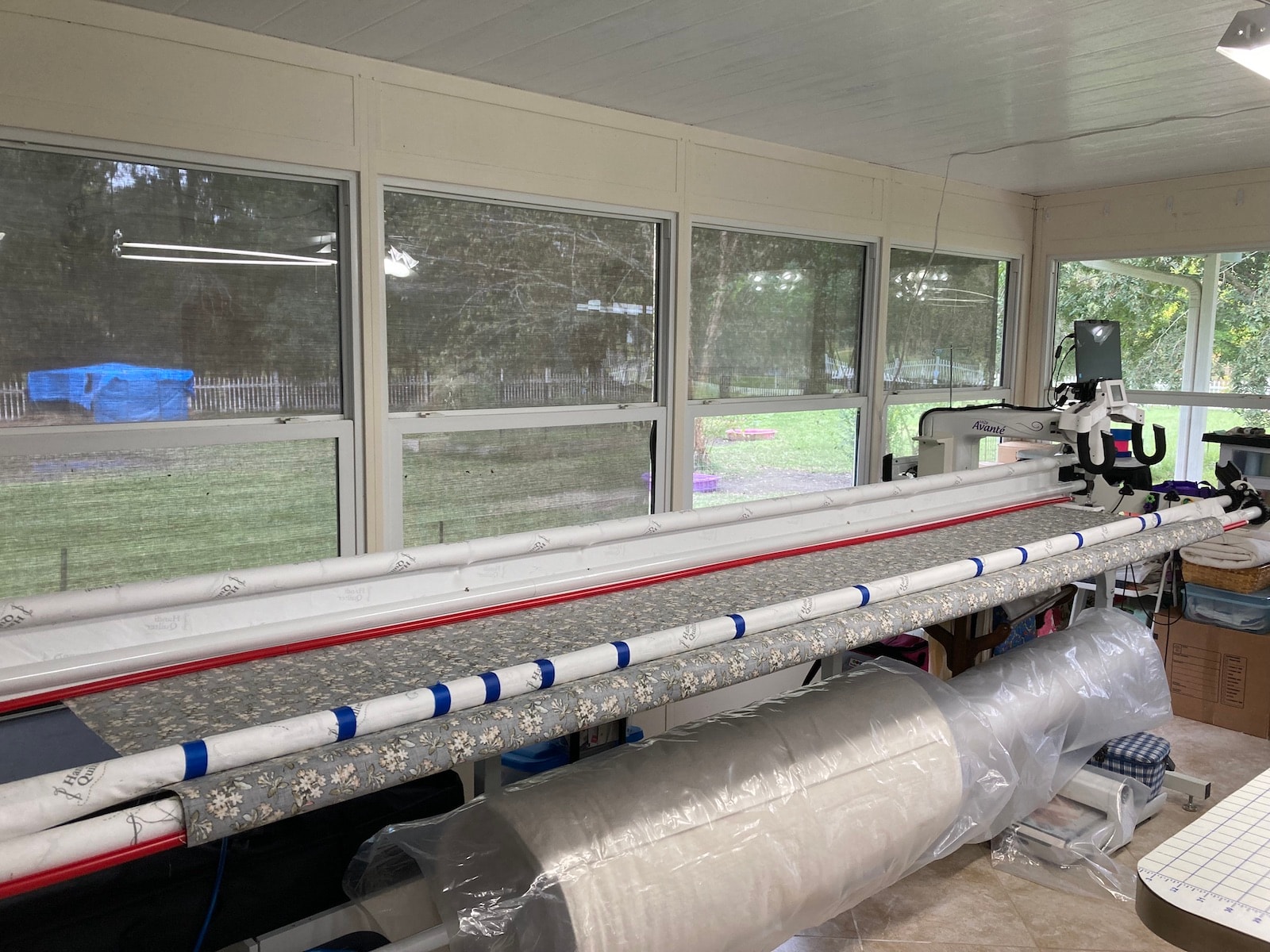 Quilt backing loaded upside down on the long arm poles with Red Snappers