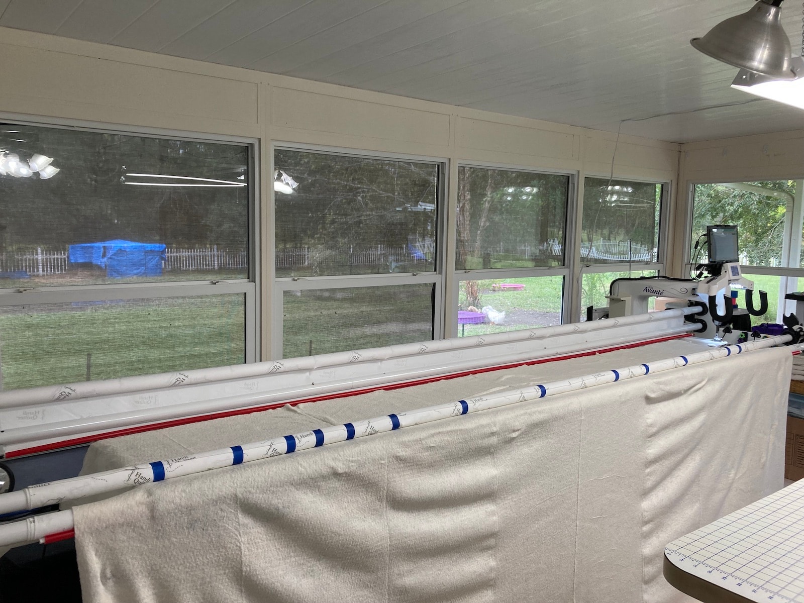 Batting laid flat on top of the backing on the long arm frame